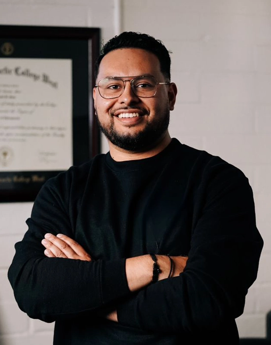 Chiropractor Daniel Soto smiling in a black shirt.